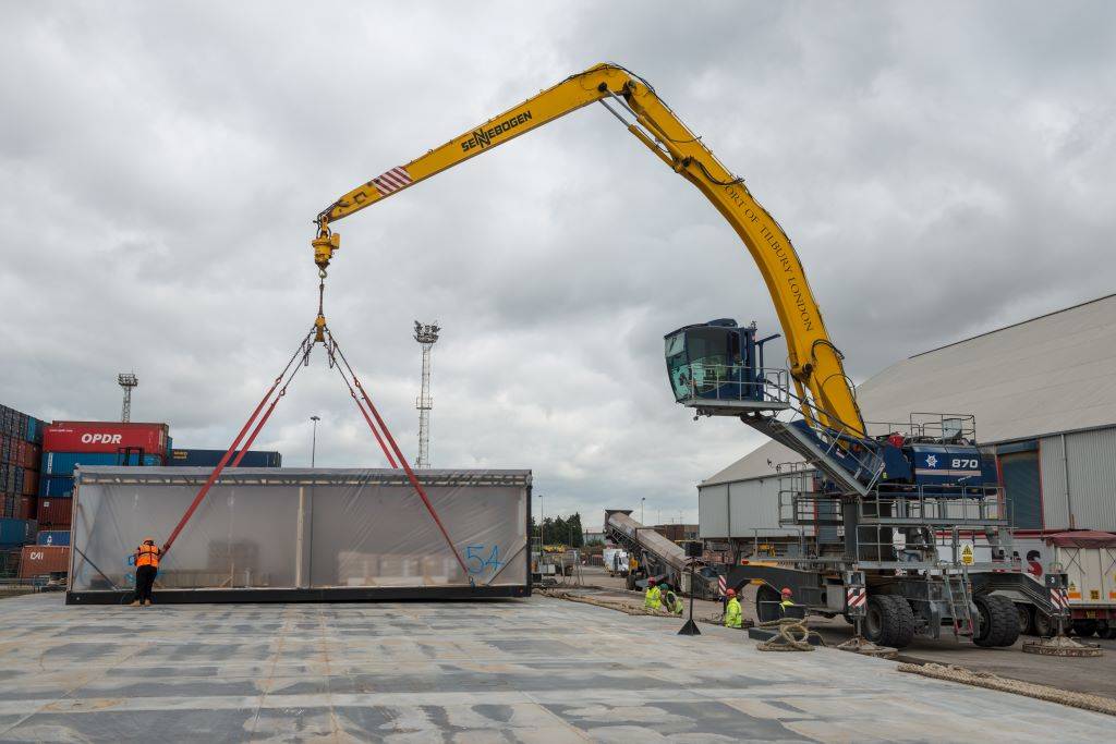 Crane lifting a unit with work people around it